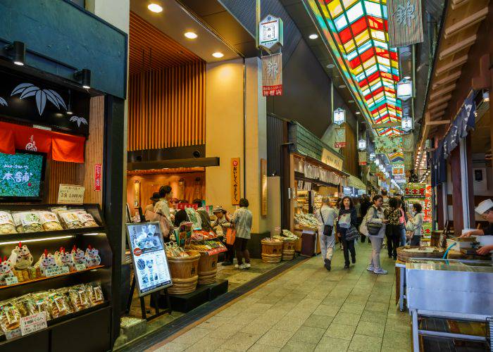 The interior of Nishiki Market, showing the hustle and bustle of Kyoto's local stalls.